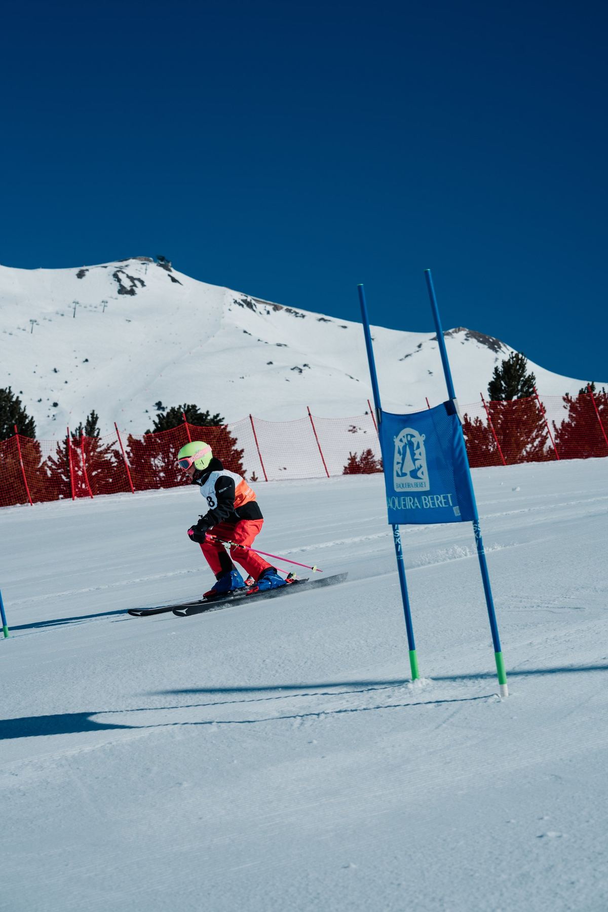 Esquiaire passant ua pòrta en Baqueira Beret